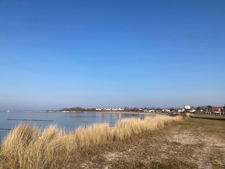 Blick vom Strand am Beginn der Schaabe zum Hafen in der Bucht